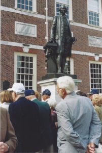 Members in front of statue